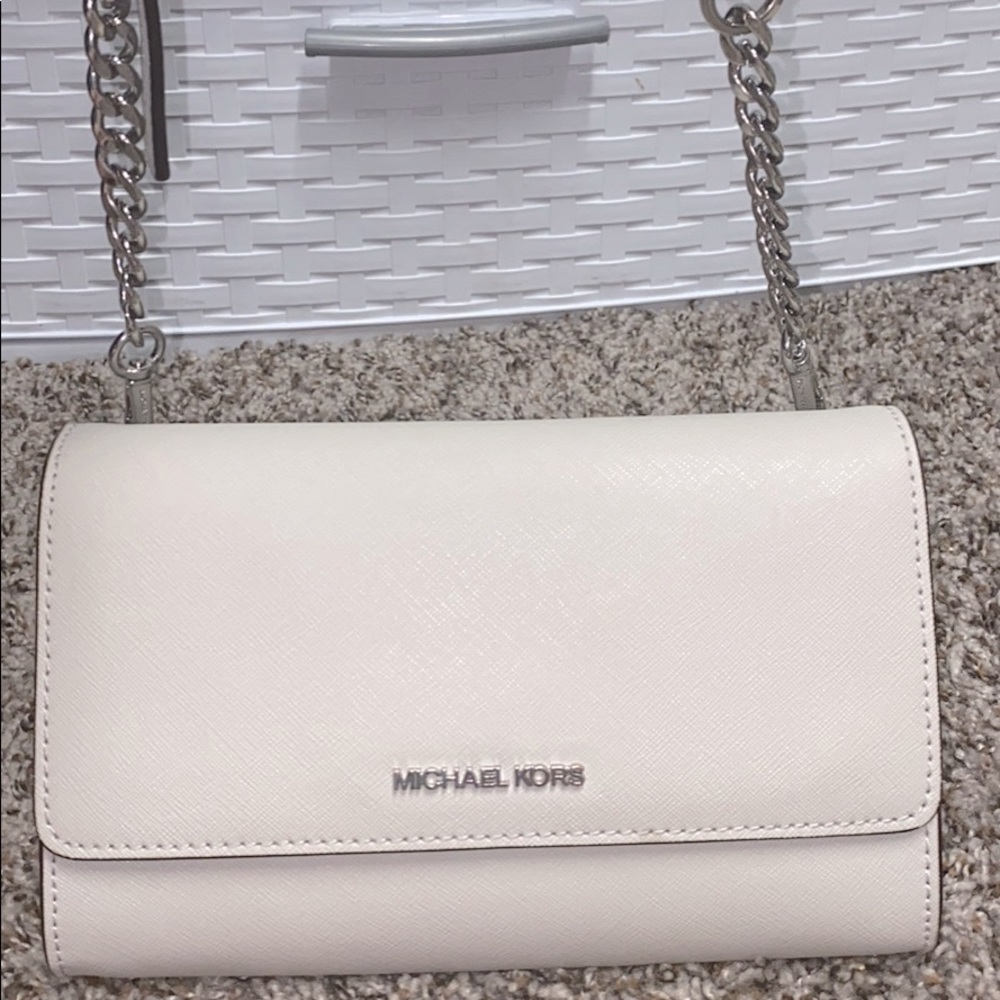 Im selling my Michael Kors Jet Set Crossbody the color is grey & real leather